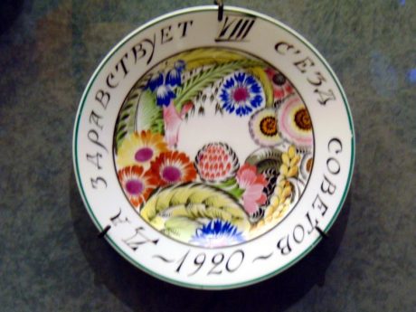 Plate “Long Live the 8th Congress of Soviets”. 1920. On side, inscriptions “Long Live the 8th Congress of Soviets 1920” in black paint. On dish, multi-coloured painting, large flowers and leaves. Body: IFZ “Nikolai II” “GFZ 1920”. Painted over glaze. Diameter, 24 cm. Collection V.A. Dudakov and M.K. Kashuro